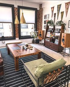 a living room filled with lots of furniture next to large windows and pictures on the wall