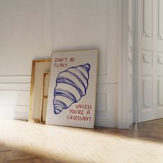 two framed pictures sitting on top of a hard wood floor next to a white wall