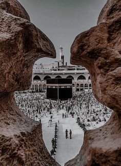 the view from behind two rocks looking at a large group of people