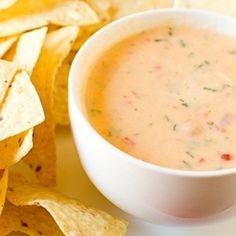 a white plate topped with chips and a bowl of dip