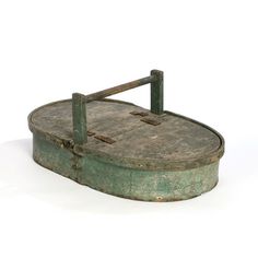 an old green metal box sitting on top of a white floor