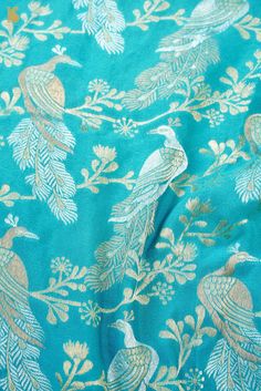 an image of a blue and gold fabric with peacocks on the back side,