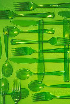 green plastic forks and spoons are arranged in a row