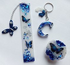 three pieces of blue and white glass with butterflies on them, including a keychain