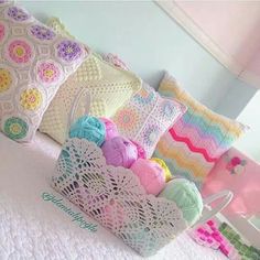 crocheted pillows and balls of yarn on a bed