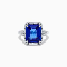 an emerald and diamond ring with blue sapphires in the center, on a white background