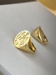 "gold family crest signet ring delicately engraved with your family crest, any other image or initials you want ♡ the stones are cubic zirconia the ring has solid back. deep and detailed engraving very delicately handcrafted unisex - looks super cool on both women & men additional inside engravings cost 12 USD. please contact us if you request inside engravins or simply go back to our shop and purchase the \"Side or inside engraving fee\" listing. this gold family creat signet ring is available Old Money Signet Ring, Family Crest Rings Men, Gold Oval Signet Ring With Coat Of Arms, Gold Engraved Ring With Coat Of Arms For Anniversary, Anniversary Signet Ring With Coat Of Arms, Anniversary Coat Of Arms Signet Ring, Luxury Signet Ring With Coat Of Arms For Anniversary, Elegant Oval Signet Ring With Coat Of Arms, Luxury Yellow Gold Signet Ring With Coat Of Arms