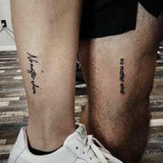 two people with matching tattoos on their legs, one is holding the other's leg