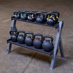 there are many kettles and dumbbells on this rack