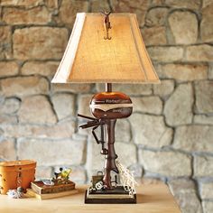 a lamp sitting on top of a wooden table next to a vase and other items