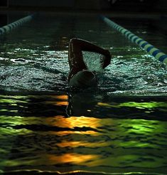 a swimmer is swimming in the pool at night