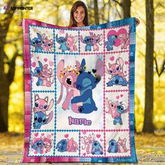 a woman holding up a blanket with cartoon characters on it