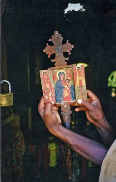 a person holding up an icon in front of a black background with the word jesus on it