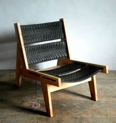 a chair made out of tire treads sitting on top of a cement floor next to a wall