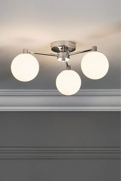 three lights are hanging from the ceiling in a room with gray walls and white trim