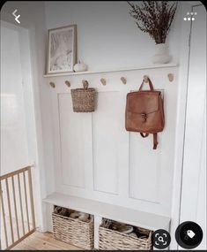 a white coat rack with baskets and purses on it next to a wooden bench