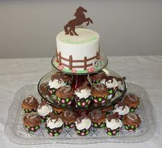 a cake and cupcakes on a glass platter