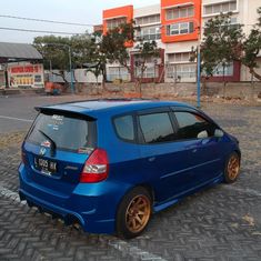 a small blue car parked in front of a building