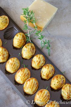 some food is sitting in a muffin tin on a table next to a piece of cheese