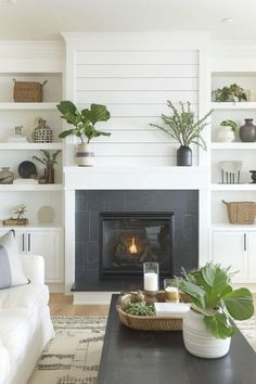 a living room filled with furniture and a fire place in front of a white fireplace