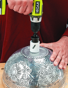 a man is using a drill to make a decorative cake with frosting on it