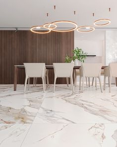 a modern dining room with marble flooring and white chairs around a round chandelier