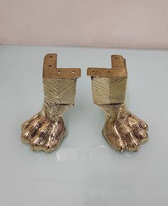 pair of gold colored metal shoes on white surface