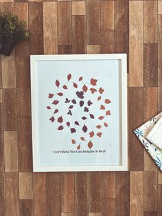 there is a framed print with leaves on it