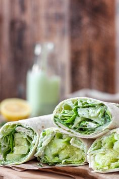 there is a wrap with lettuce in it on the table next to some lemons