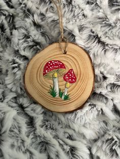 a wooden ornament with mushrooms on it sitting on top of a furry surface