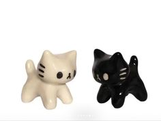 two black and white ceramic cats sitting next to each other