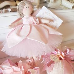 a pink doll is sitting next to some flowers