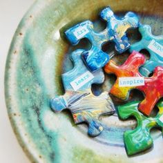 a ceramic bowl filled with colorful pieces of puzzle