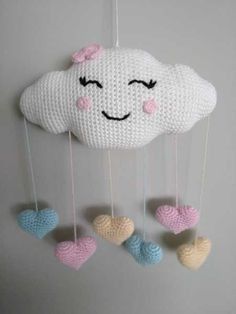 a crocheted cloud with hearts hanging from it's sides and eyes drawn on the clouds