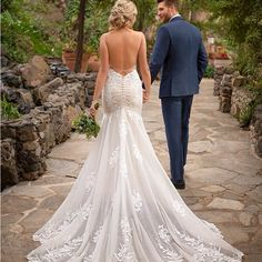 a bride and groom walking down a stone path