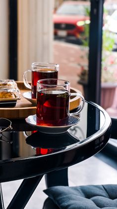 two cups of tea sitting on top of a table