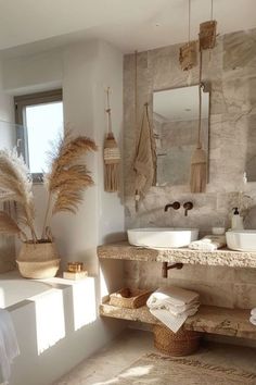 a bathroom with two sinks, mirrors and towels on the counter top in front of a window