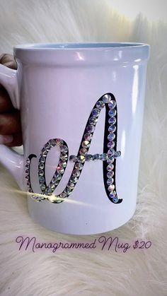 a white coffee cup with the letter a on it and some beads in the middle