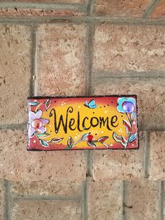 a brick wall with a welcome sign on it