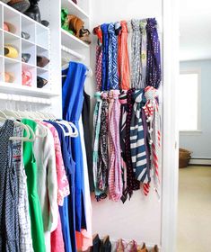 a closet filled with lots of different types of scarves and shoes hanging on the wall