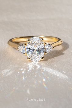 a three stone diamond ring on a white surface