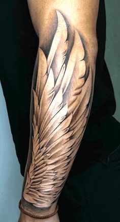 a man's arm with an artistic tattoo design on the arm and wings painted on it