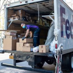 a man unloading boxes from the back of a truck