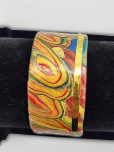 Golds and red colors swirl with a creative flow edged with a gold strip. Elegant, 1 inch wide cuff/bracelet Artisan Red Adjustable Cuff Bracelet, Adjustable Red Artisan Cuff Bracelet, Adjustable Artisan Red Cuff Bracelet, Hand Painted Gold Bracelets For Gift, Gold Hand Painted Bracelets As Gift, Gold Hand Painted Bracelets For Gift, Multicolor Adjustable Cuff Bracelet For Formal Occasions, Adjustable Multicolor Cuff Bracelet For Formal Occasions, Unique Red Bracelet As Gift