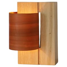 a wooden wall light with a brown shade on it's side and a white background