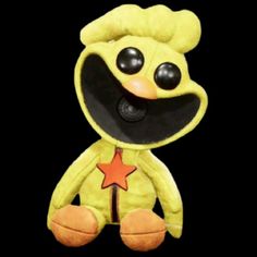 a yellow stuffed animal with black eyes and a star on it's chest, sitting in front of a black background