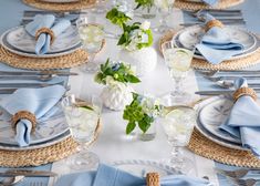 the table is set with blue napkins and place settings for an elegant dinner party