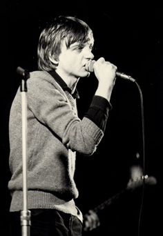 black and white photograph of a man singing into a microphone