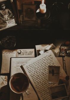 an open book sitting on top of a table next to a cup of coffee and other items