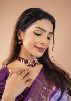 This Kundan Choker set showcases a stunning combination of Multilayer Red Beads, Kundan, and a central Red Stone, accented by delicate white micro stones. The result is a beautiful interpretation of traditional sophistication with a contemporary twist. This exquisite necklace set features multiple layers of vibrant red beads, adorned with intricate Kundan detailing, creating a luxurious and opulent look. The rich red hue adds a sense of boldness and sophistication to the ensemble. Dangling red beads further accentuate the Choker's allure, creating movement and adding a touch of drama to the piece. Perfect for festive occasions and special events, this necklace set is a statement accessory that commands attention and exudes confidence and grace. Note: This jewelry has no precious metals or House Of Blouse, Kundan Choker Set, Kundan Choker, Red Beads, Choker Set, Lace Print, Designer Blouses, Indian Festivals, Indian Weddings